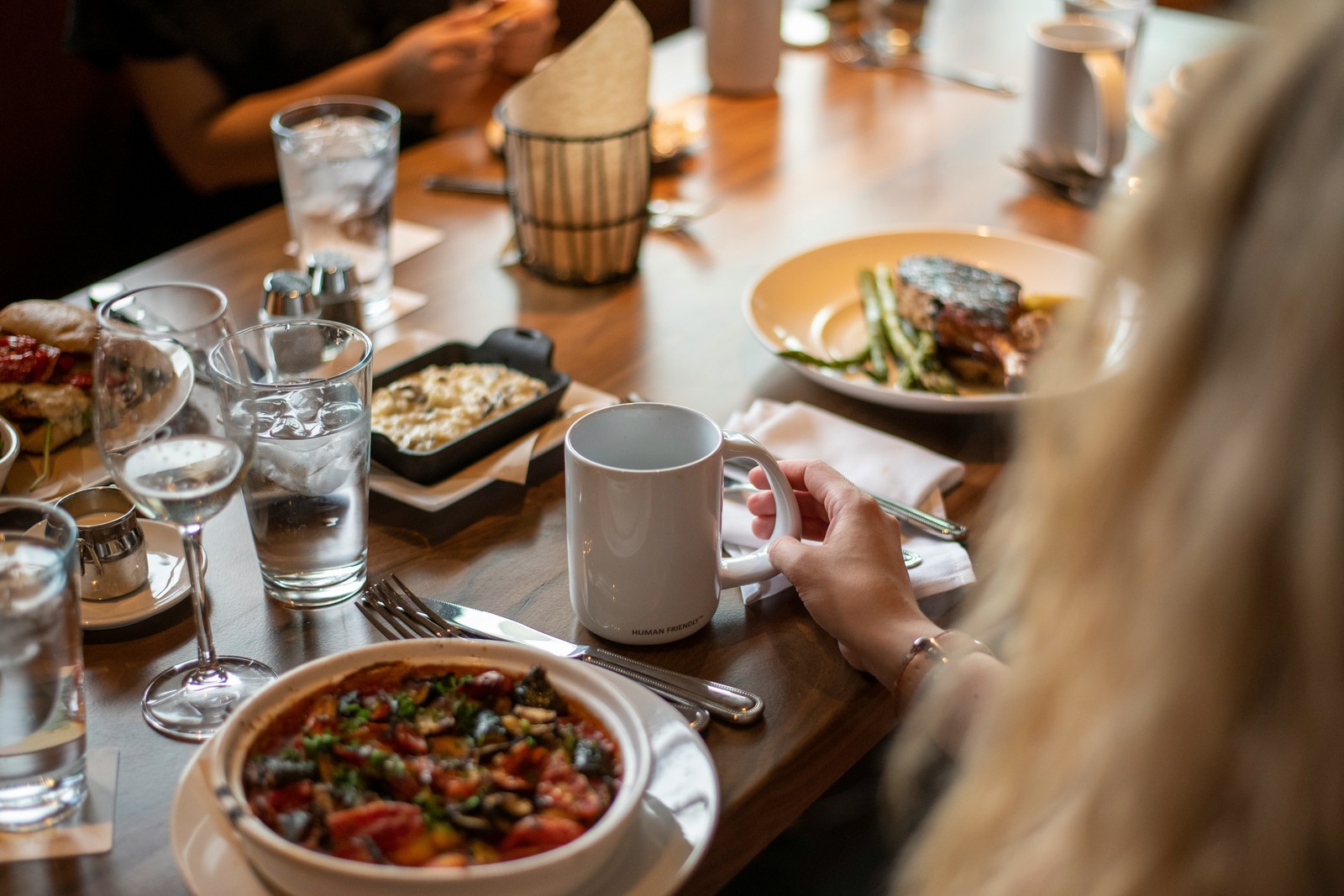 Overhead view of a restaurant table with multiple dishes and a white mug.